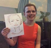 Екатерина в красном платье, улыбаясь показывает свой шарж