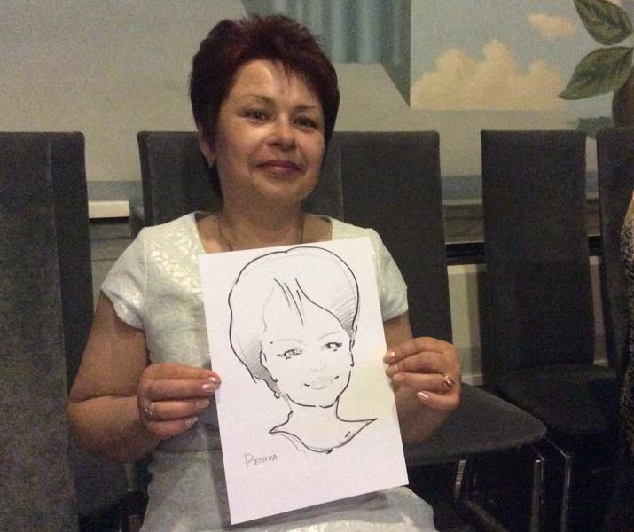 Регина демонстрирует свой шарж на свадьбе