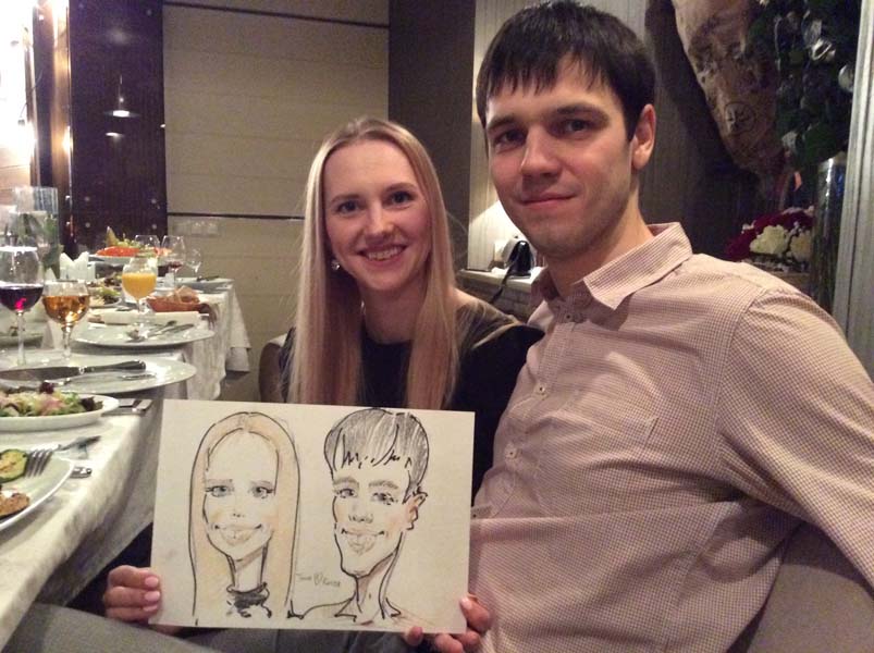 Таня и Костя позируют шаржисту Мишелю на свадьбе